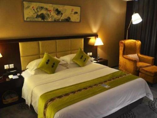 a hotel room with a large bed and a chair at Hefei Parkview Hotel in Hefei