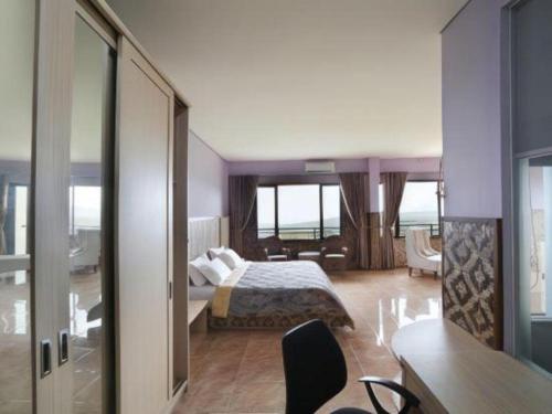 a bedroom with a bed and a living room at Fafa Hill Hotel and Resort in Bogor