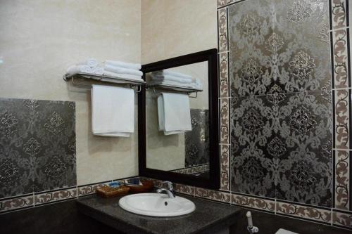 un bagno con lavandino e specchio di Anoulack Khen Lao Hotel a Muang Phônsavan