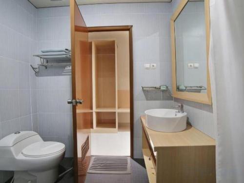 a bathroom with a toilet and a sink and a mirror at Fafa Hill Hotel and Resort in Bogor