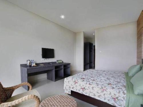 a bedroom with a bed and a desk and a television at Fafa Hill Hotel and Resort in Bogor