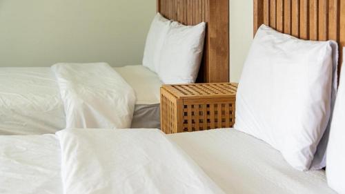 two beds in a room with white sheets and pillows at Gallery Pension in Taean