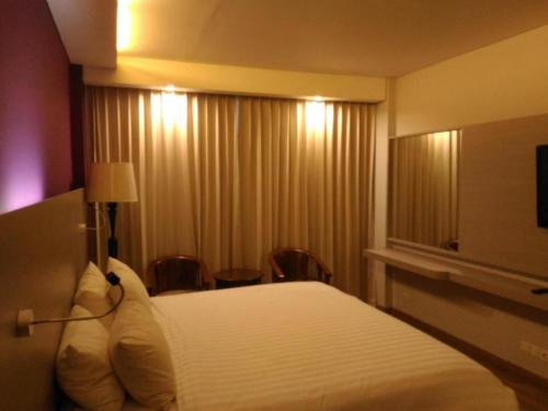 a hotel room with a bed and a window at Kharisma Hotel in Madiun