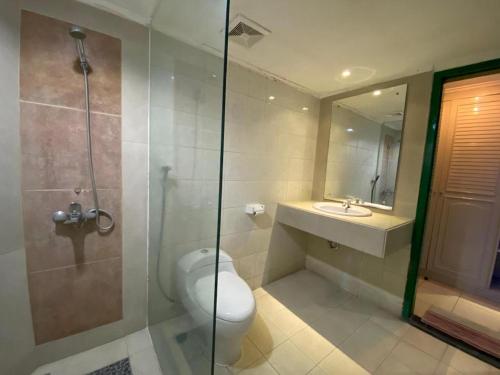 a bathroom with a toilet and a sink and a shower at Kharisma Hotel in Madiun