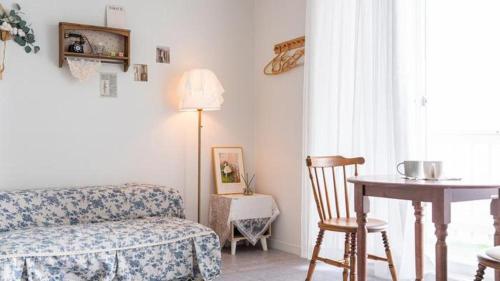 a living room with a couch and a table and a chair at Gallery Pension in Taean