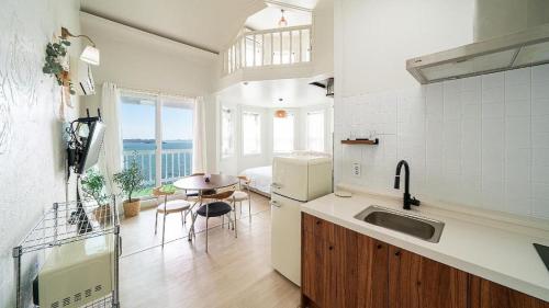 a kitchen with a sink and a table in a room at Gallery Pension in Taean