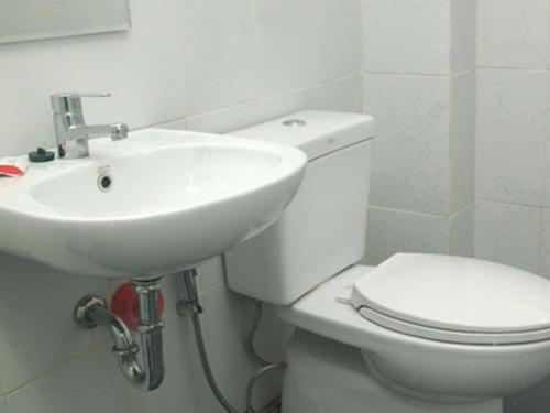 Un baño con un inodoro blanco y un lavabo. en Selabintana Conference Resort, en Sukabumi