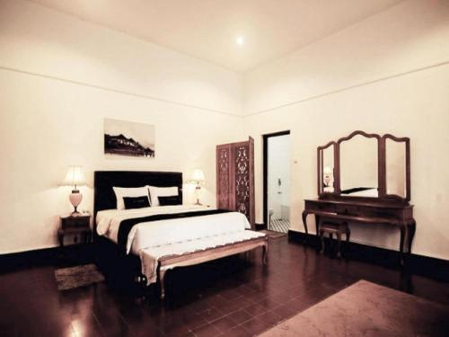 1 dormitorio con cama, espejo y piano en Selabintana Conference Resort, en Sukabumi