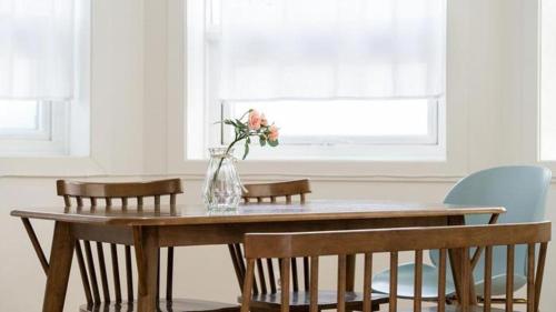 a dining room table with chairs and a vase with flowers at Gallery Pension in Taean