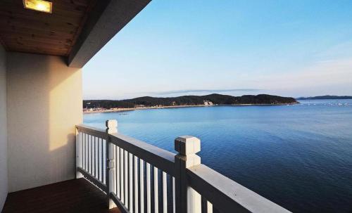 a balcony of a house with a view of the water at Gallery Pension in Taean