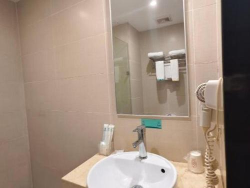 a bathroom with a sink and a mirror at City Comfort Inn Guilin Xing'an in Xing'an
