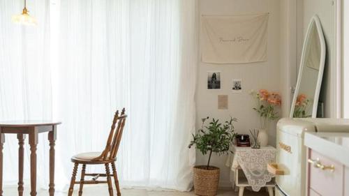 a room with a table and a chair and a window at Gallery Pension in Taean