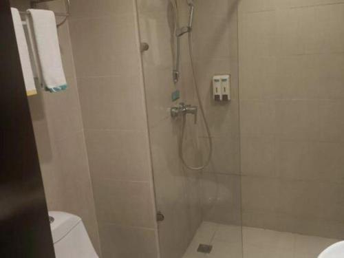 a bathroom with a shower with a glass door at City Comfort Inn Guilin Xing'an in Xing'an