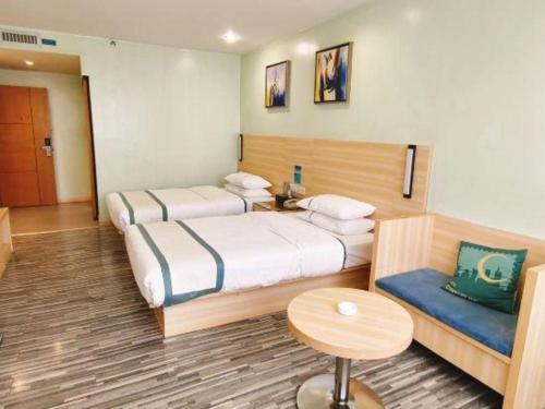 a hotel room with two beds and a table at City Comfort Inn Guilin Xing'an in Xing'an
