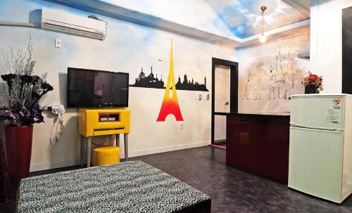 a room with a tv on a wall at Gallery Pension in Taean