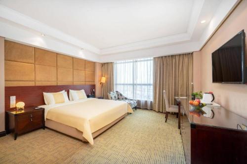 a hotel room with a bed and a television at Chinflux Mandarin Hotel in Dongguan