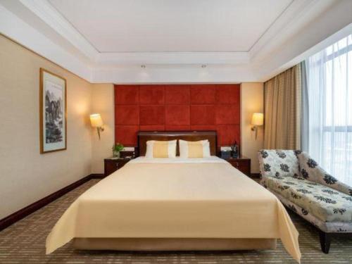 a hotel room with a large bed and a couch at Chinflux Mandarin Hotel in Dongguan