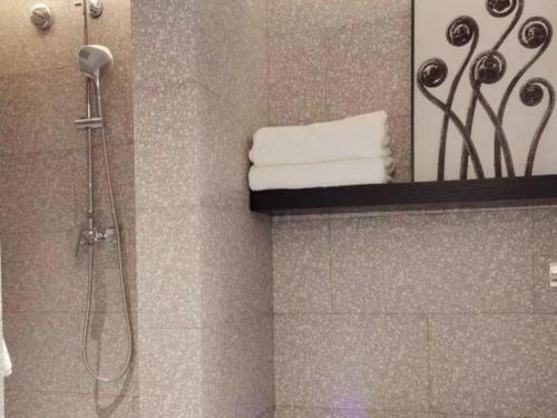 a shower in a bathroom with a mirror at Zaozhuang Hotel in Zaozhuang