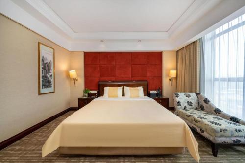 a hotel room with a large bed and a couch at Chinflux Mandarin Hotel in Dongguan