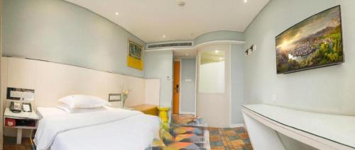 a bedroom with a bed and a painting on the wall at Zaozhuang Hotel in Zaozhuang