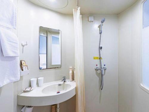 a bathroom with a sink and a shower at Zaozhuang Hotel in Zaozhuang