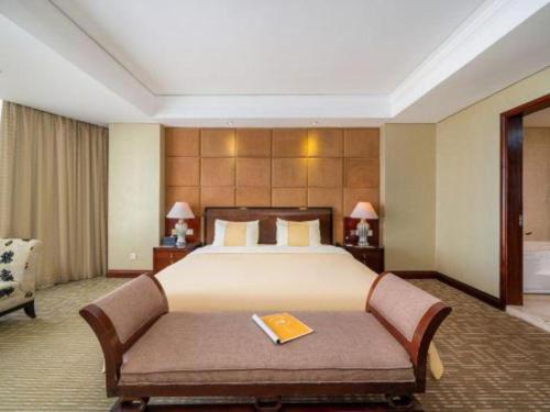 a large hotel room with a bed and a couch at Chinflux Mandarin Hotel in Dongguan