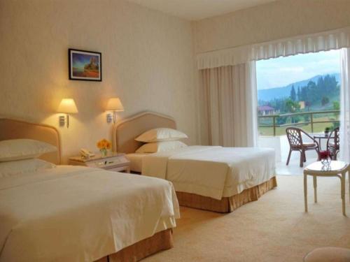 Postel nebo postele na pokoji v ubytování Grand Mutiara Hotel