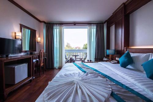 a bedroom with a large bed with a large window at The Palm Hotel in Sihanoukville