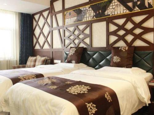 a bedroom with two beds with white and brown blankets at Zaozhuang Hotel in Zaozhuang