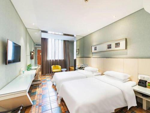 a hotel room with two beds and a desk at Zaozhuang Hotel in Zaozhuang