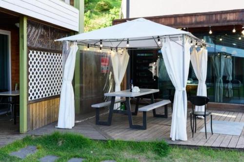 a picnic table under an umbrella on a deck at All That Water Pension in Gapyeong