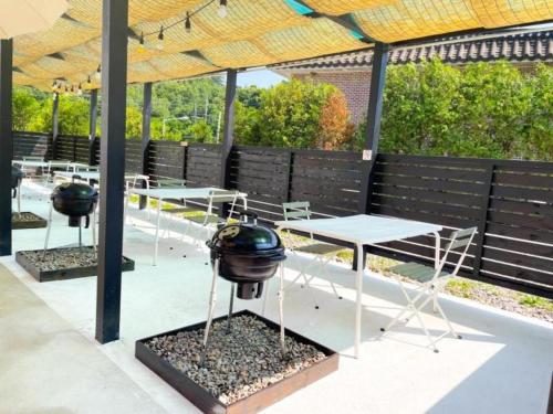 a picnic table with a grill on it in a patio at All That Water Pension in Gapyeong