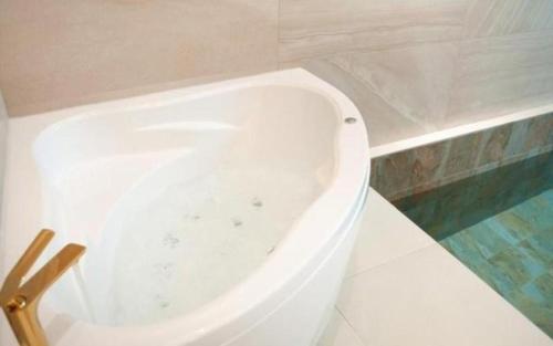 a white bath tub sitting next to a toilet at All That Water Pension in Gapyeong