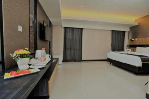 a hotel room with a bed and a table with food at Fitra Hotel Majalengka in Majalengka