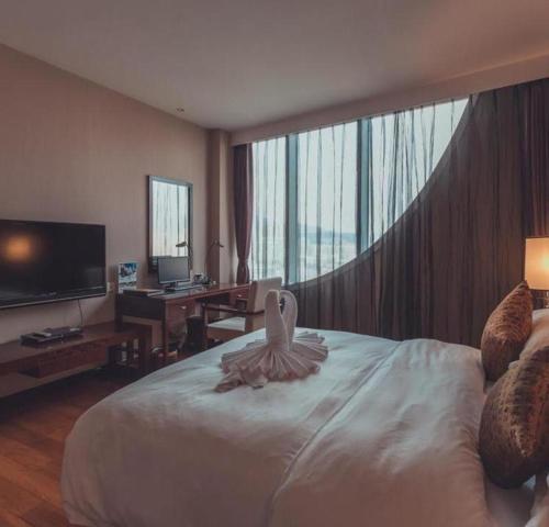 a bedroom with a large white bed with a large window at Kunming Wenhui Hotel in Kunming