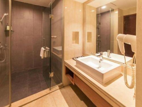 a bathroom with a sink and a shower at Oriental Hotel in Dongguan