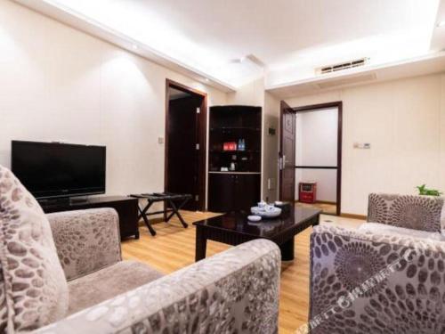 a living room with two couches and a flat screen tv at Oriental Hotel in Dongguan