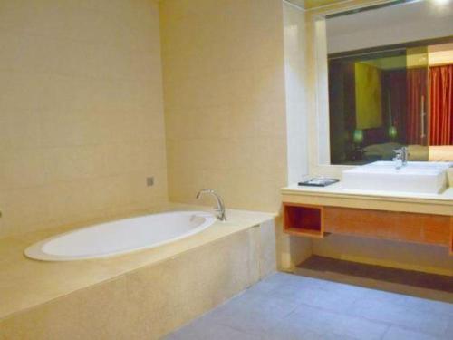 a bathroom with a tub and a sink at Oriental Hotel in Dongguan