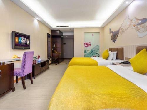 a hotel room with two beds with yellow blankets at Oriental Hotel in Dongguan