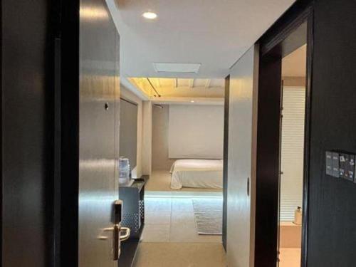 a door to a bedroom with a bed in a room at Oriental Hotel in Dongguan