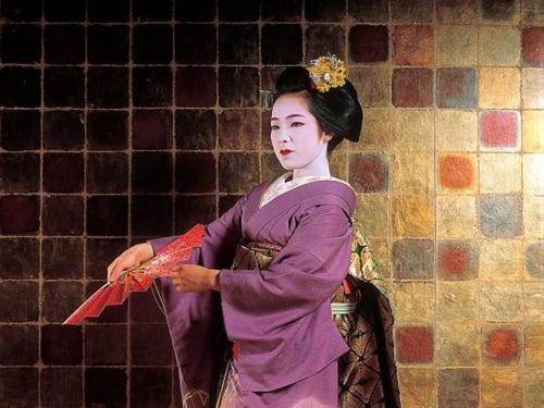 a woman in a purple dress holding a kite at Kyoto Hot Spring Hatoya Zuihokaku Hotel in Kyoto