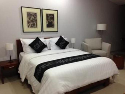 a bedroom with a large white bed and a chair at VillaTel Salse in Bandung