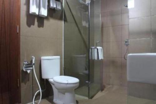a bathroom with a toilet and a glass shower at VillaTel Salse in Bandung