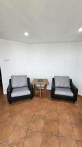 two black chairs in a room with a table at VillaTel Salse in Bandung