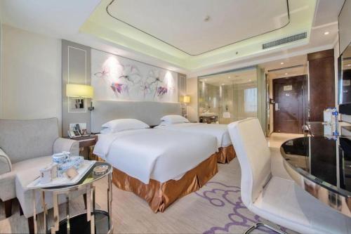 Pokój hotelowy z dużym łóżkiem i kanapą w obiekcie Noble Jasper Hotel Huizhou w mieście Huizhou