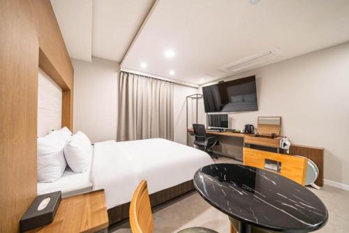 a hotel room with a bed and a desk at Seven Motel Ansan in Ansan