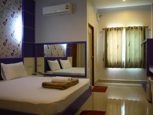 a bedroom with a bed with a mirror on it at Sabai Ez Hotel in Songkhla