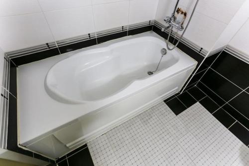 a white bath tub in a black and white bathroom at Seven Motel Ansan in Ansan