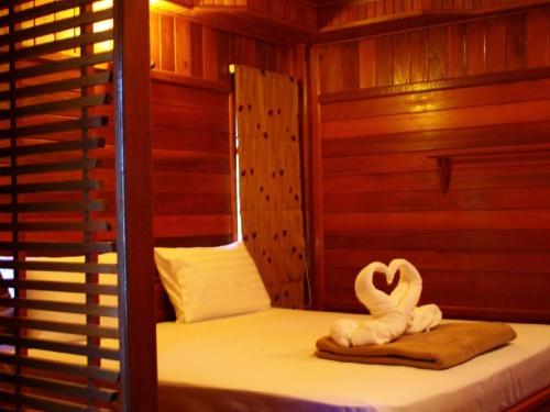 a room with a bed with two swans on it at Sabai Ez Hotel in Songkhla