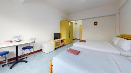 una camera con 2 letti, una scrivania e un computer di Premier Hotel Nakhonsrithammarat a Nakhon Si Thammarat